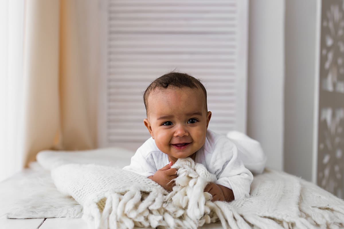 Portrait of a mixed race baby boy laying on the bed