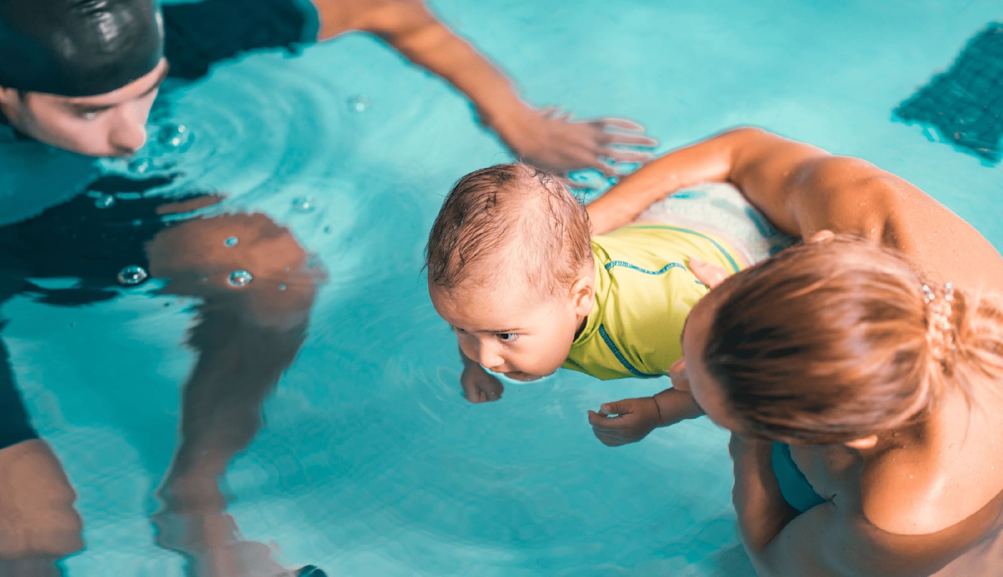 Mother with baby boy and swimming instructor, indoor swimming pool