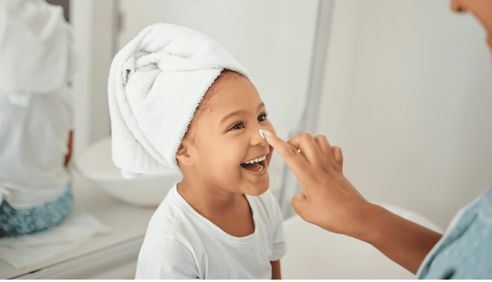 Untitled-2200-x-1265-px-2024-10-09T212134 Skincare, cream and girl child at home with mother with a happy smile in a bathroom.