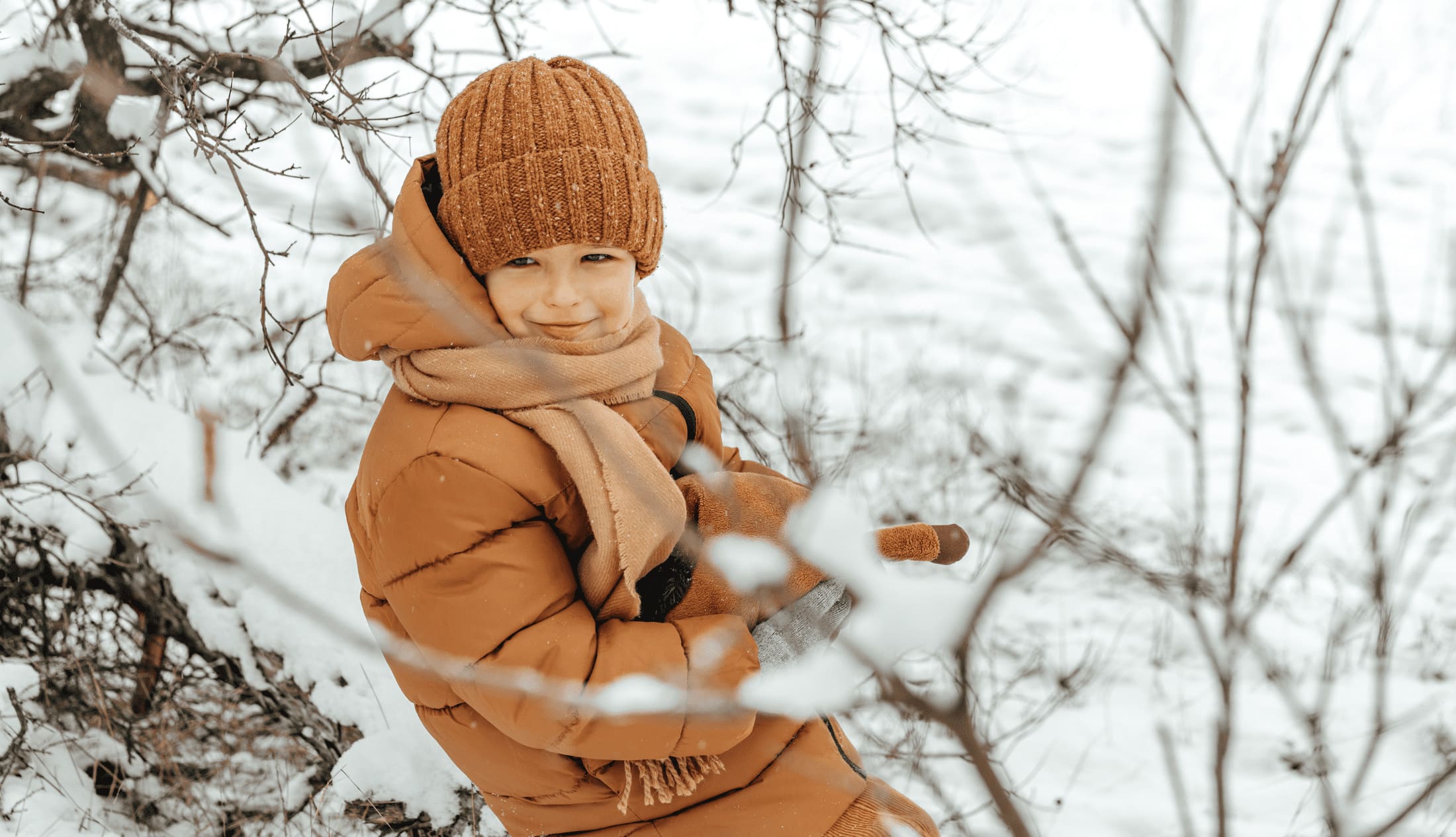 Little boy in a winter park or forest enjoying the cold without worry of illness due to a boosted immune system.